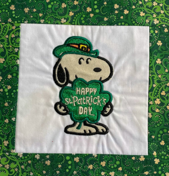Snoopy holding shamrock with white and green vinyl on white cotton