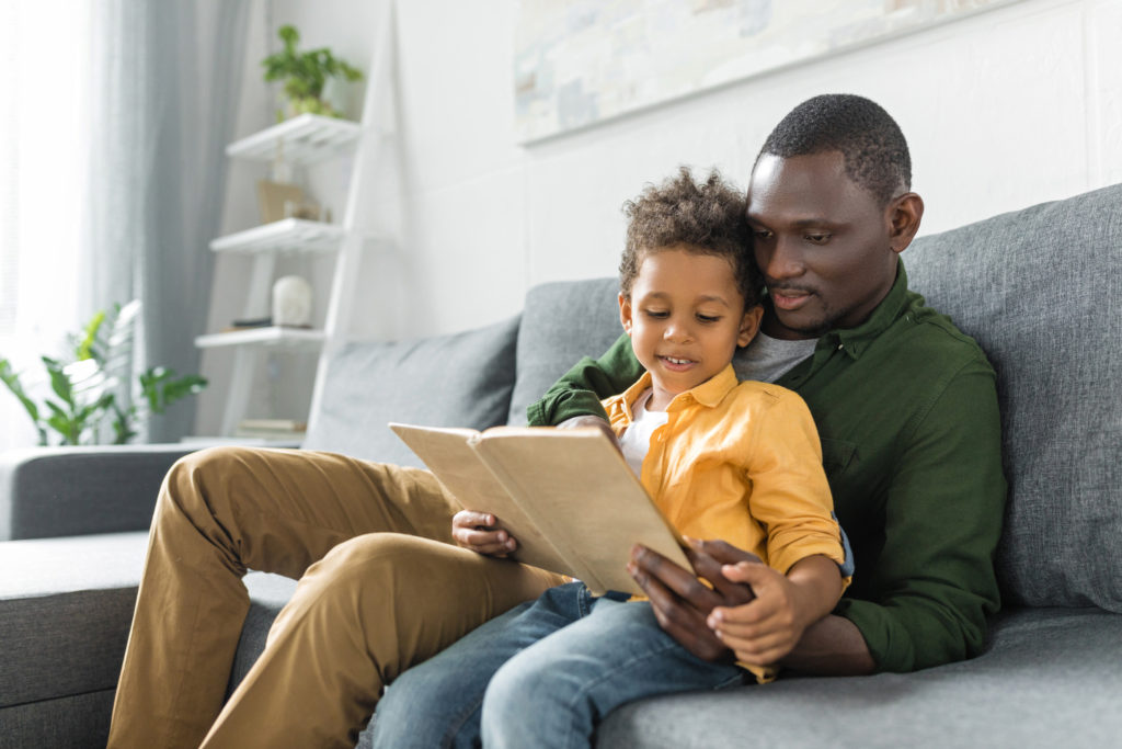 boy and father reading on the couch
