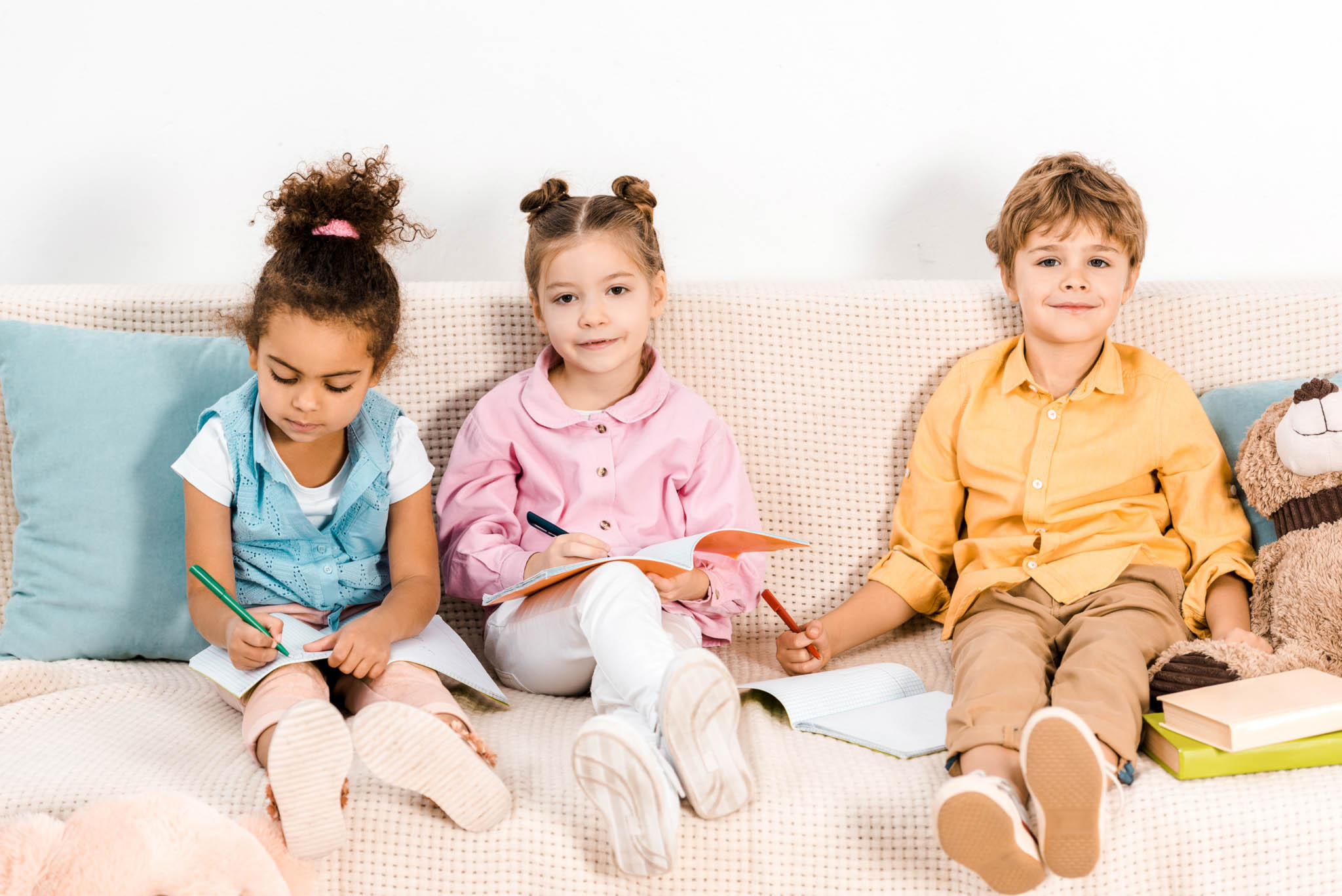 three kids on a couch with books