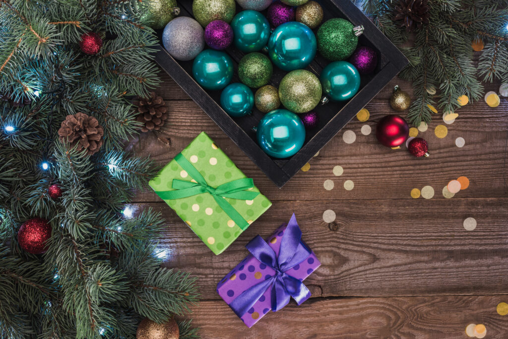 evergreen, pine cones, and ornaments and two gifts sitting on a floor
