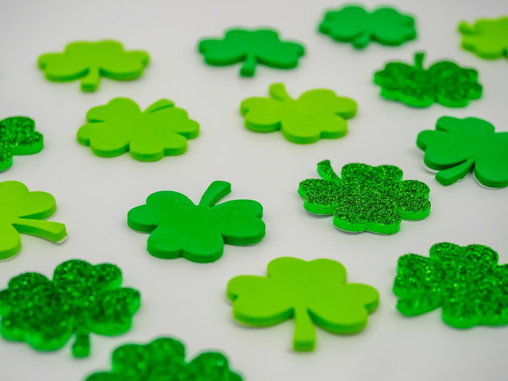 green sparkle, green, and light green shamrocks on a white table