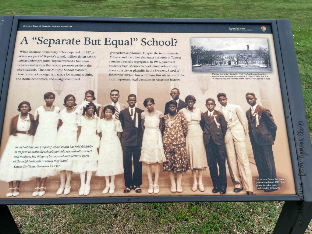 sign outside with information several at parking lot and in front of school this one says separate but equal school