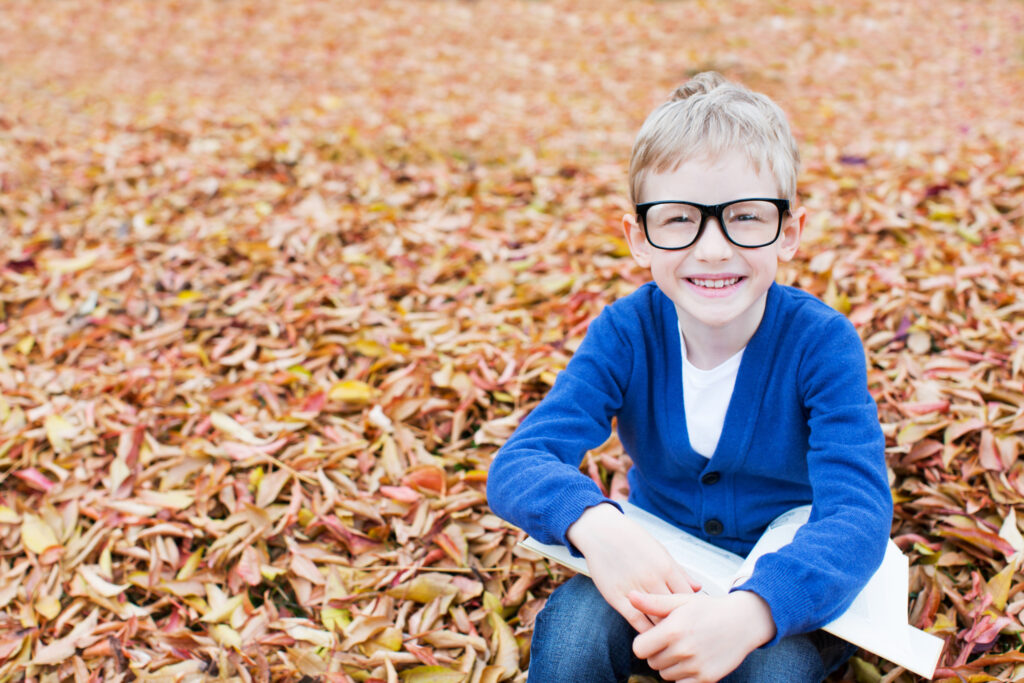 schoolboy in glasses reading book ready for fall reading