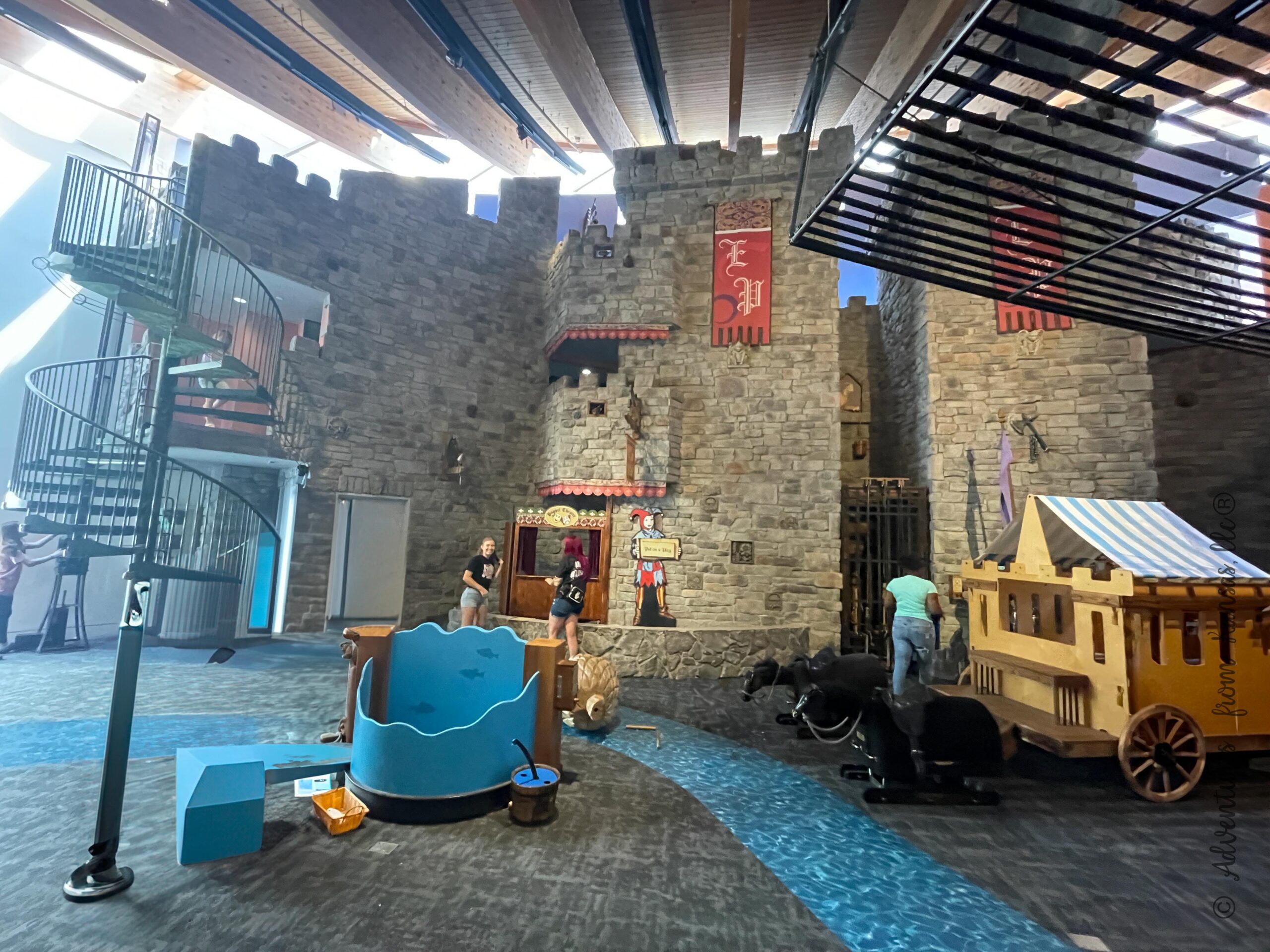 Where Kids Rule Exhibit, 3 story castle shows pond, river carpet, wagon