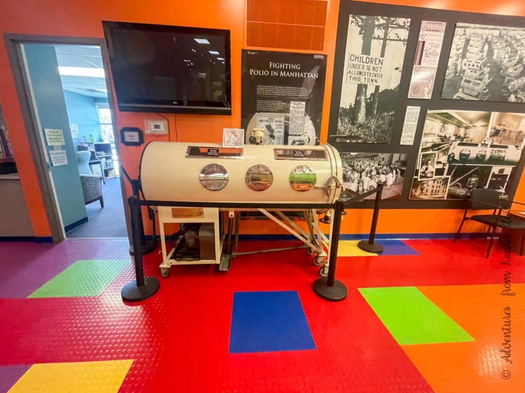 iron lung, display on wall with newspapers and signs about the polilo inside the Learning Center of Health